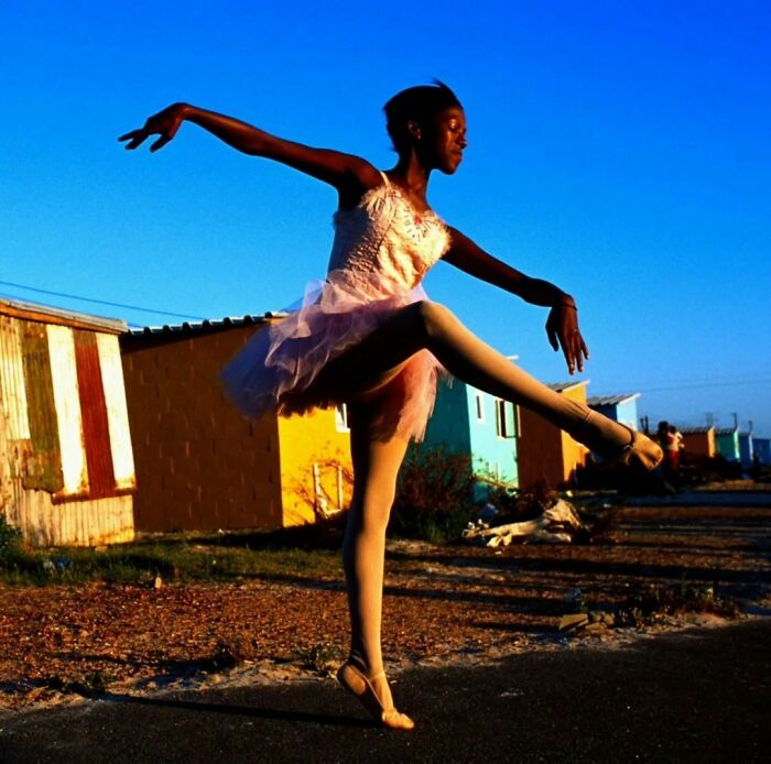 Noluyanda Mqutwana baila frente a su cobertizo familiar en Khayelitsha, una de las zonas de negros más pobres fuera de Ciudad del Cabo (Sudáfrica, 2000)