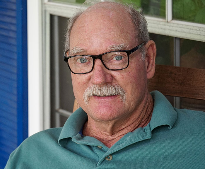 Old man wearing blue shirt and glasses