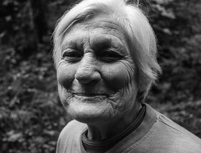 Smiling elderly woman outdoors, embodying the spirit of wise and funny advice from grandparents.