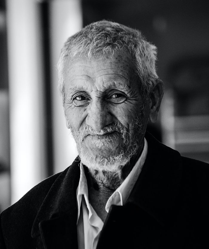 Old man smiling, embodying wisdom and warmth, reflecting 42 pieces of wise and funny advice from grandparents.