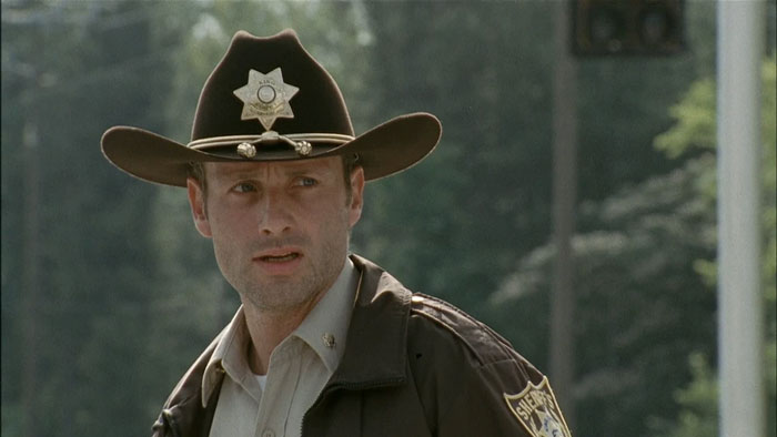 Rick Grimes wearing police clothes looking from The Walking Dead Days Gone Bye