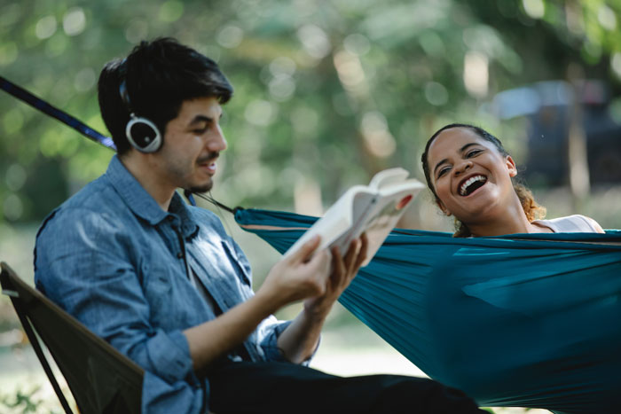 Person reading a book and other one laughing