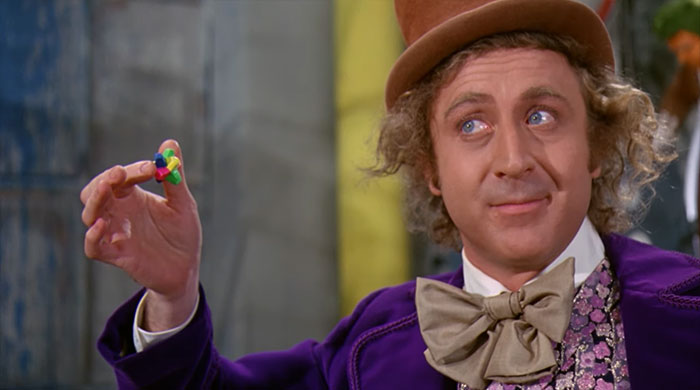Willy Wonka holding a piece of chewing gum