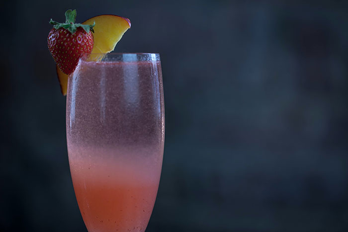 Glass of The Bellini cocktail with strawberry and peach