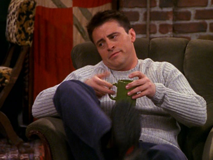Joey drinking coffee from green mug 
