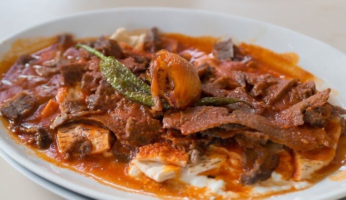 İskender, Turkey. Sliced Doner Meat Topped W/ Tomato Sauce Over Pieces Of Pita Served W/ Yogurt