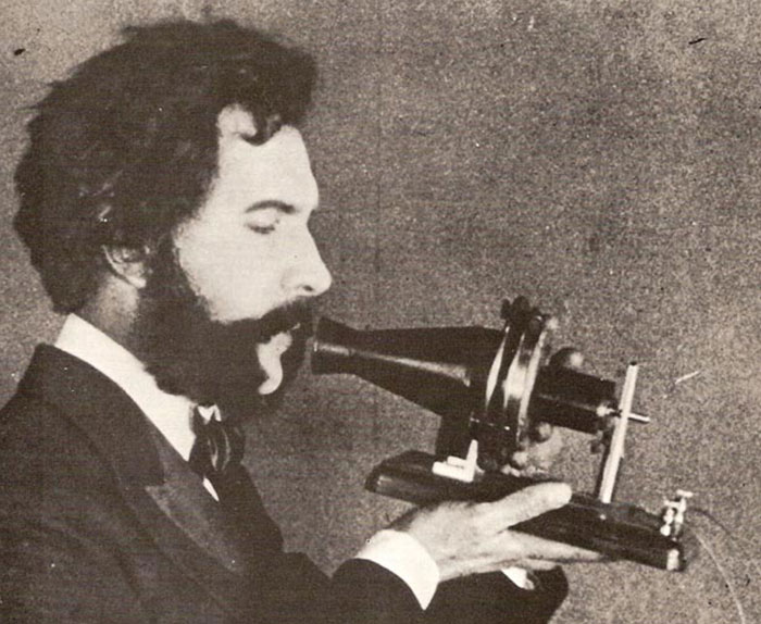 An Actor Portraying Alexander Graham Bell Speaking Into An Early Model Of The Telephone For A 1926 Promotional Film By The American Telephone And Telegraph Company