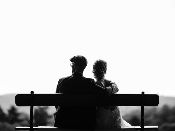 Woman and man hugging and sitting on the bench 