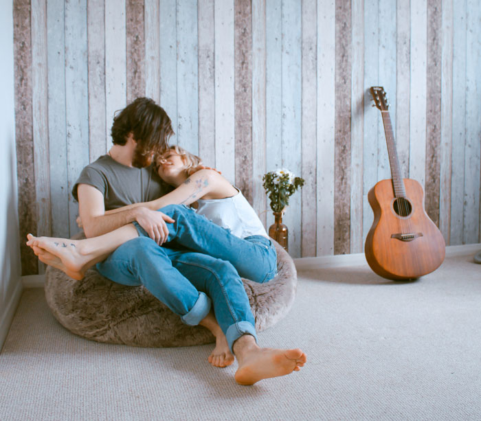 Woman and man hugging and looking themself into the eyes while sitting on bean bag