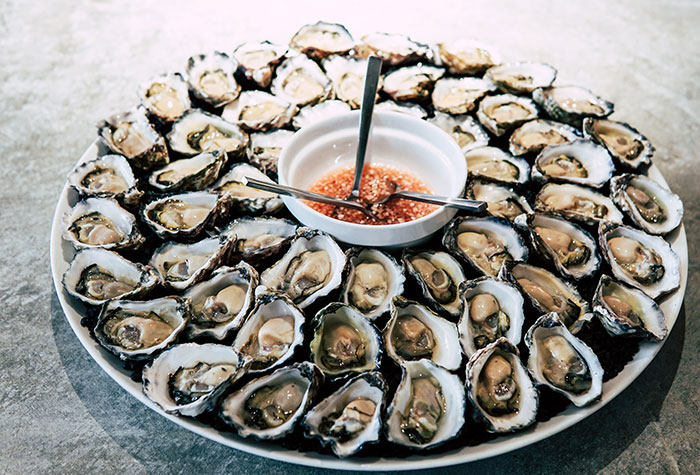 Oysters In A Bowl With Sauce In The Middle