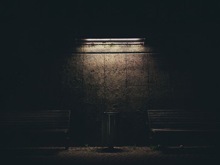 Trash Bin And Couple Of Benches On A Light In A Night 