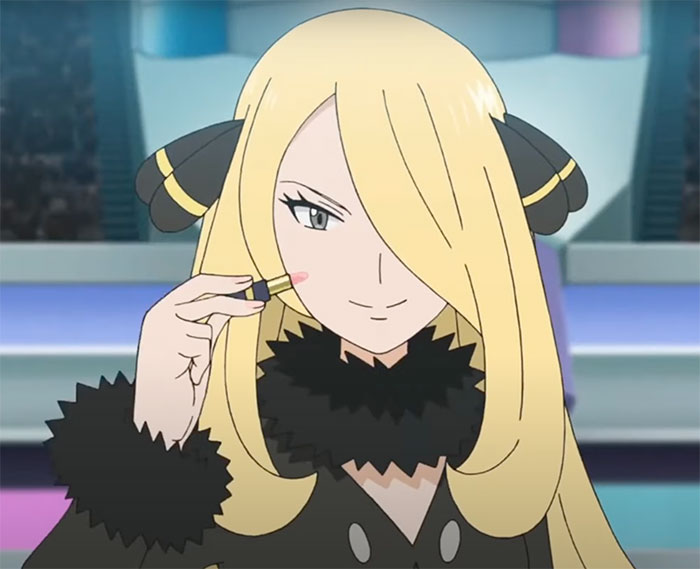 Cynthia is holding a lipstick in her right hand