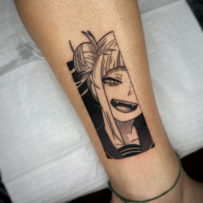 Anime character pop culture tattoo on forearm, featuring detailed black and white design with expressive eyes and fangs.