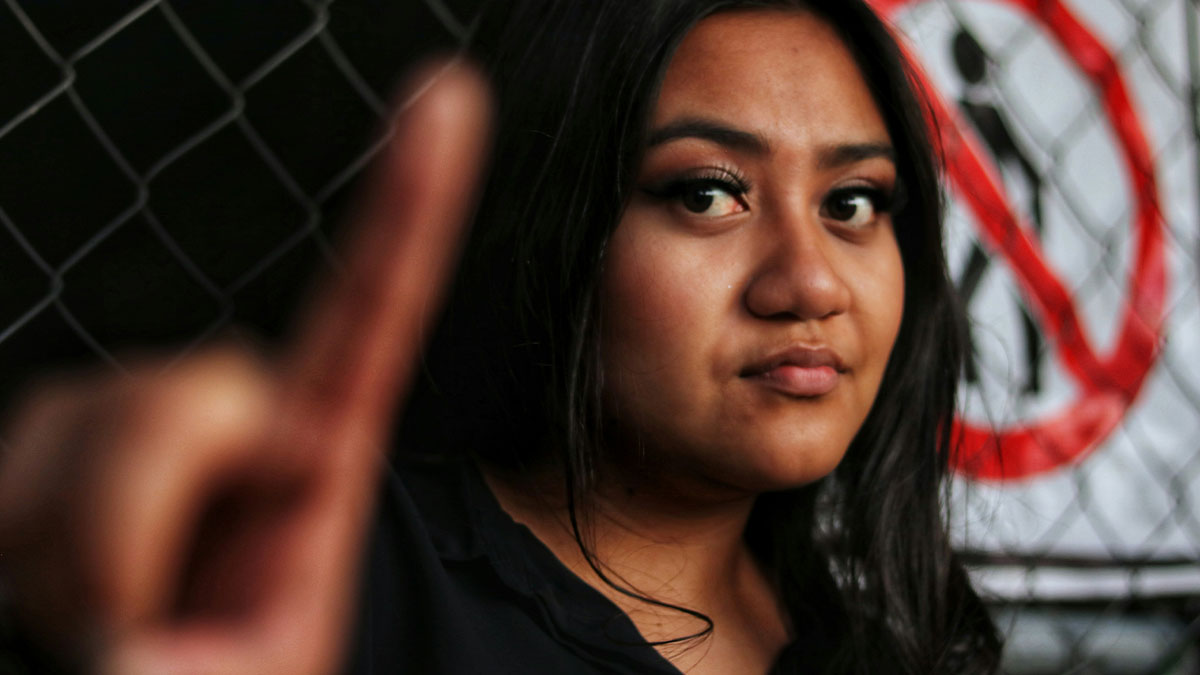 Young woman with serious expression raising her finger, highlighting moments of zero common knowledge realization.