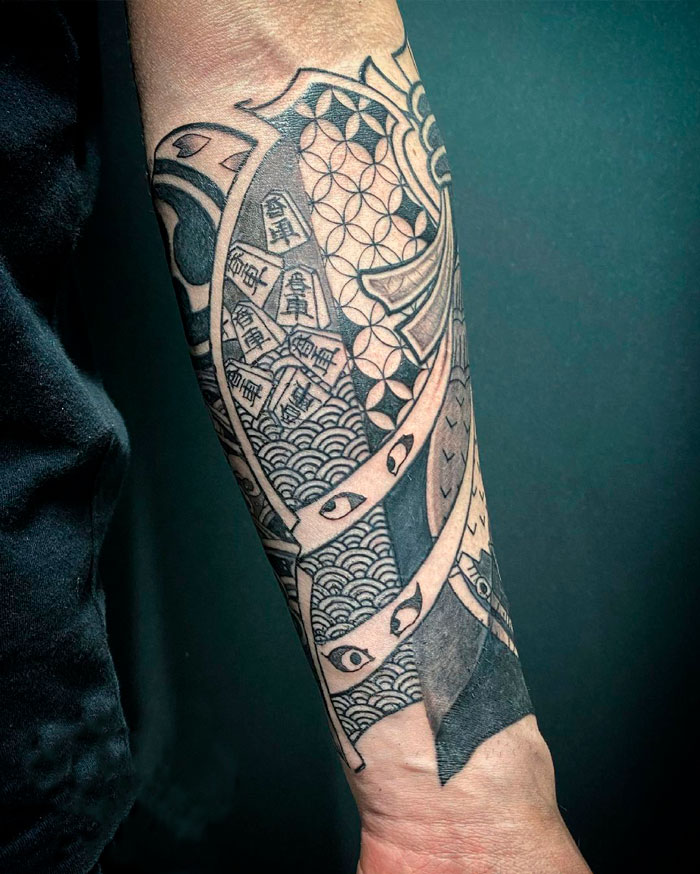 A detailed tribal tattoo on a person's forearm, featuring geometric patterns and wave designs.