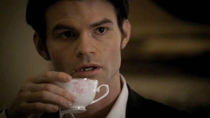 Elijah drinking from small white porcelain cup