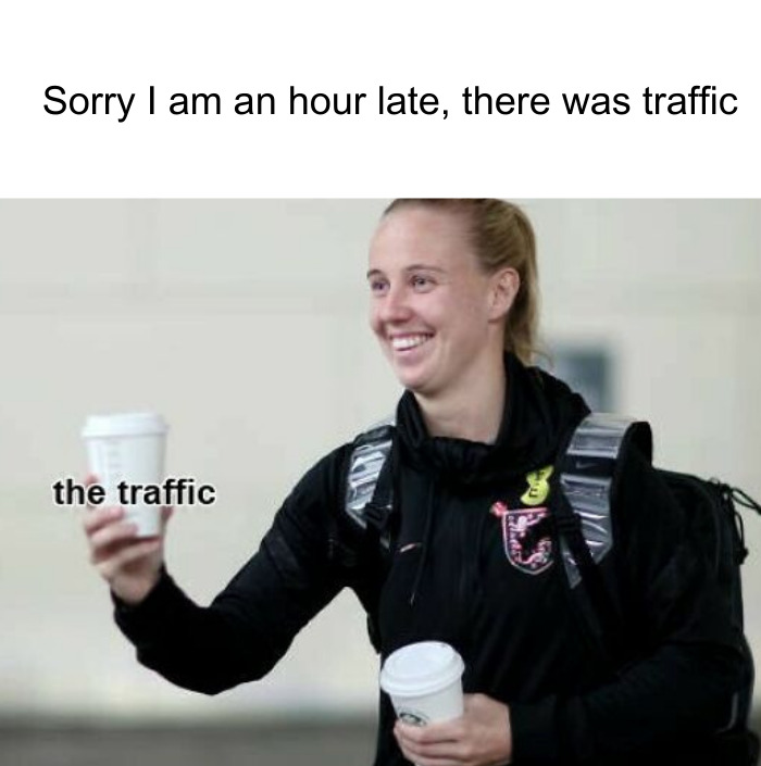 A coffee meme featuring an image of a smiling woman holding two takeaway coffee cups. The text above the image reads, "Sorry I am an hour late, there was traffic." The word "traffic" is humorously placed as a label on one of the coffee cups, implying that the real reason for being late was stopping for coffee. The meme playfully excuses tardiness by blaming it on "traffic," which is represented by the coffee.