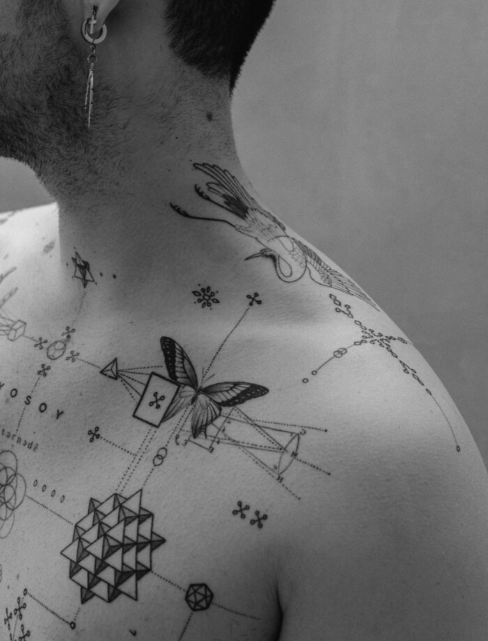 Geometric tattoo art on a person's shoulder and chest, featuring abstract and nature-inspired designs in black ink. Geometric tattoo art on a person's shoulder and chest, featuring abstract and nature-inspired designs in black ink.