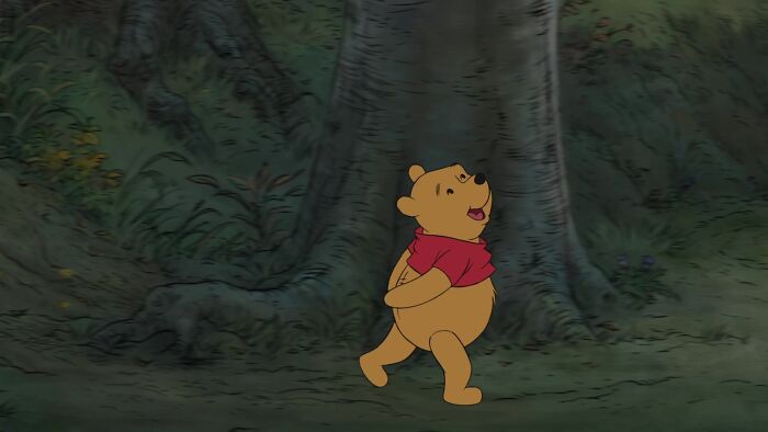 Winnie The Pooh walking in the forest