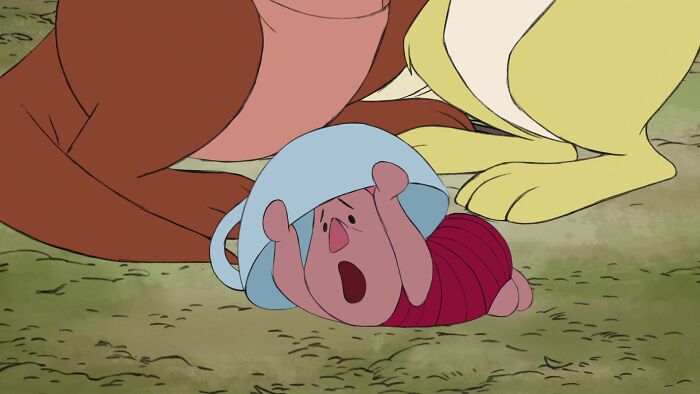 Piglet from Winnie the Pooh lying with a bowl on his head