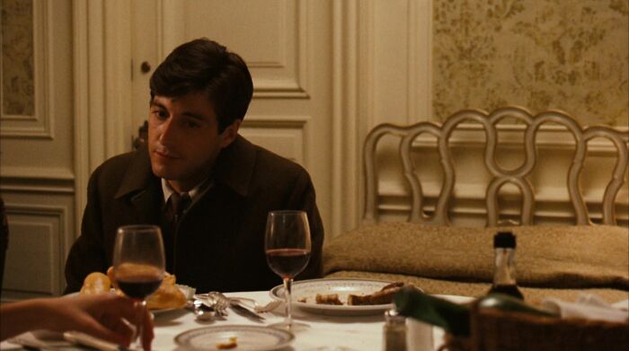 Michael Corleone sitting at a table