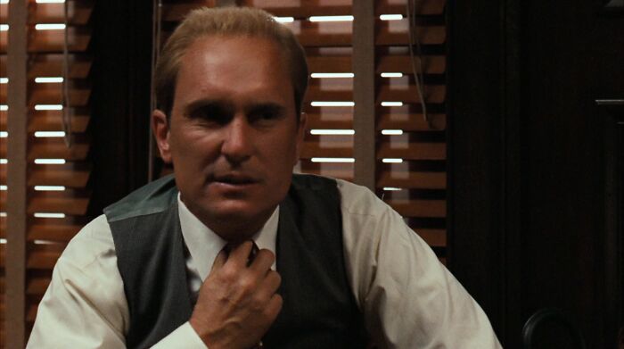 Tom Hagen looking straight while holding his tie 