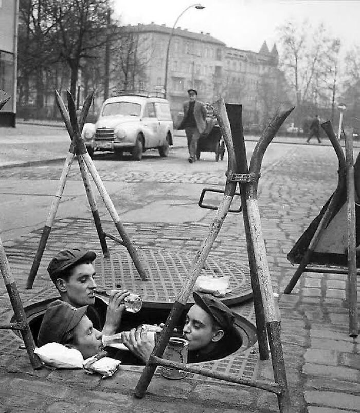 1957. Three Workers Having Breakfast In An Open Manhole, Berlin. Photo By Konrad Giehr