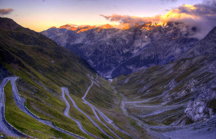 Sunset, Passo Dello Stelvio, Italy. Motorcycle Ride Down An Icy Road*
