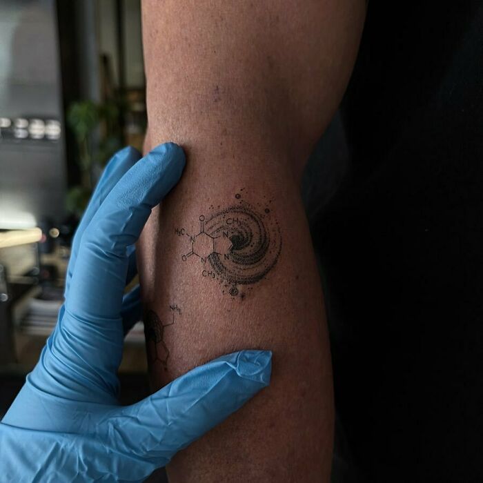 Tiny cosmic molecules tattoo on arm