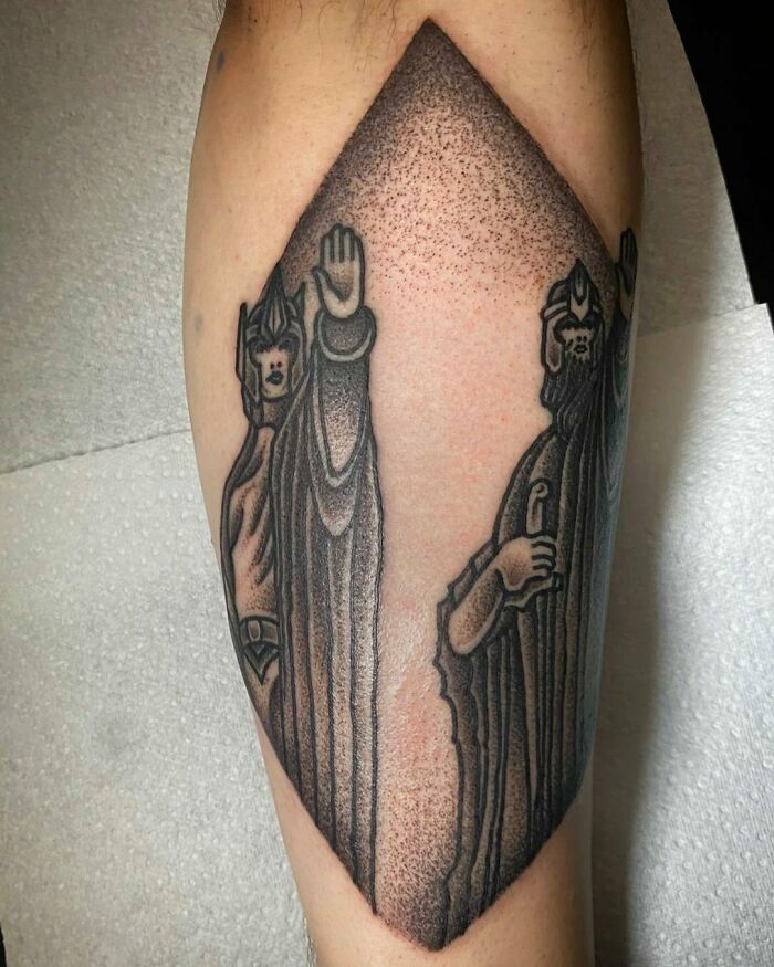 "Detailed Lord of the Rings tattoo depicting iconic characters on an arm in black ink, showcasing intricate artistry."