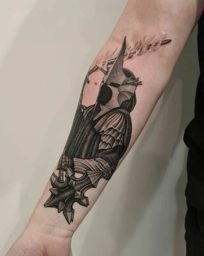 "Detailed Lord of the Rings tattoo featuring armored character on forearm."
