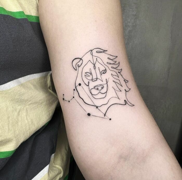 Zodiac tattoo of a lion with constellation design on a person's arm.