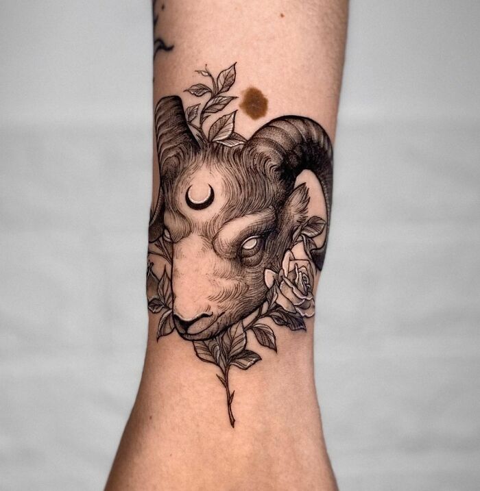Aries zodiac tattoo with floral details on forearm.