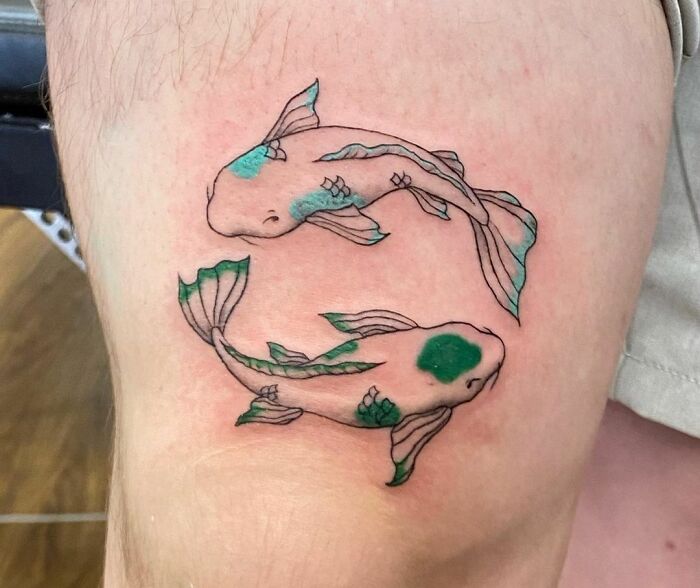 Tattoo of two koi fish swimming in a circle, symbolizing zodiac sign Pisces.