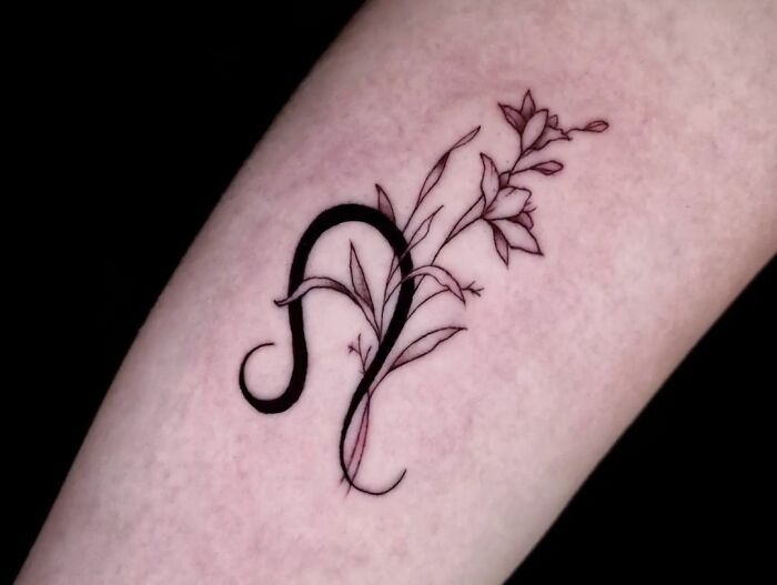 Leo S]symbol with flowers tattoo