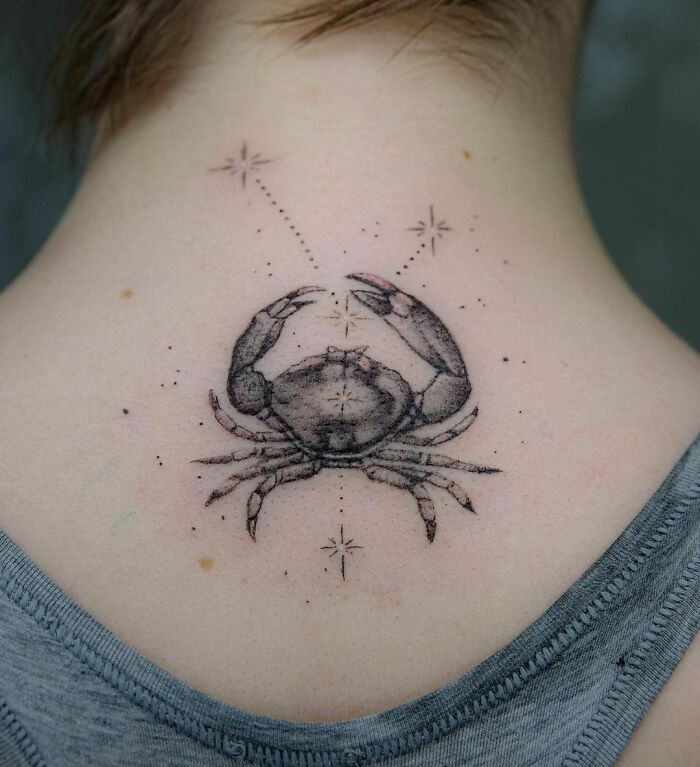 Crab zodiac tattoo on the back, detailed with stars and dots in a constellation design.