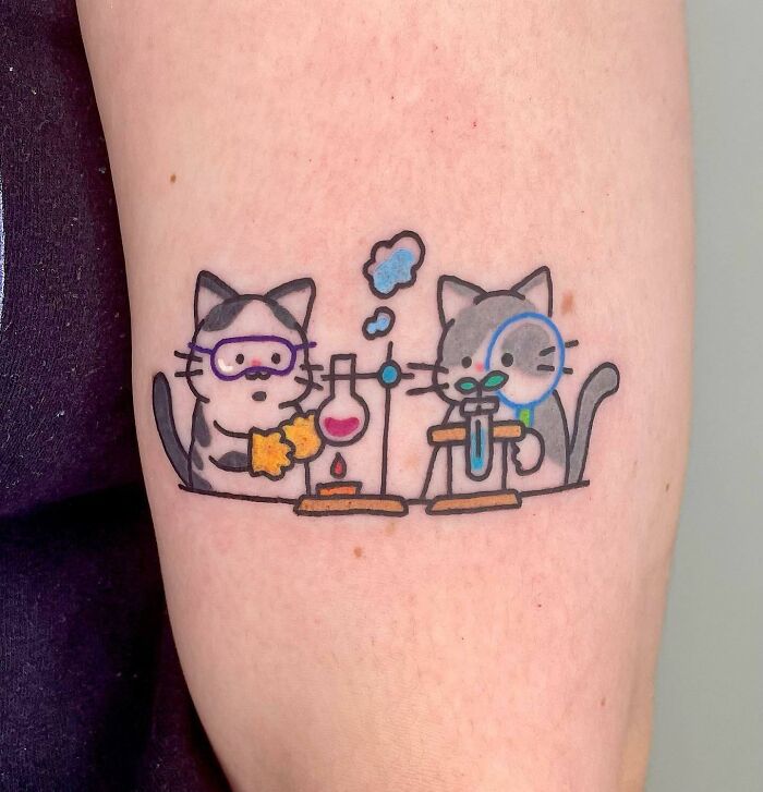 Two cats doing chemistry cartoon tattoo