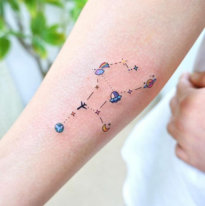 Tiny cartoon exploration tattoo on arm
