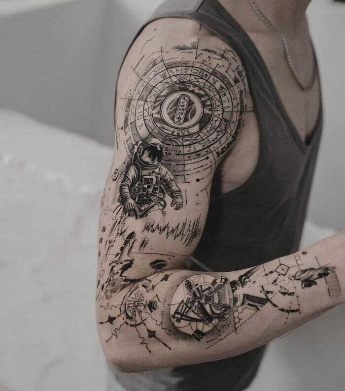 Black and grey astronaut arm tattoo