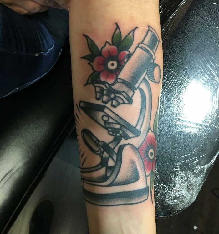 Microscope and flowers tattoo on arm
