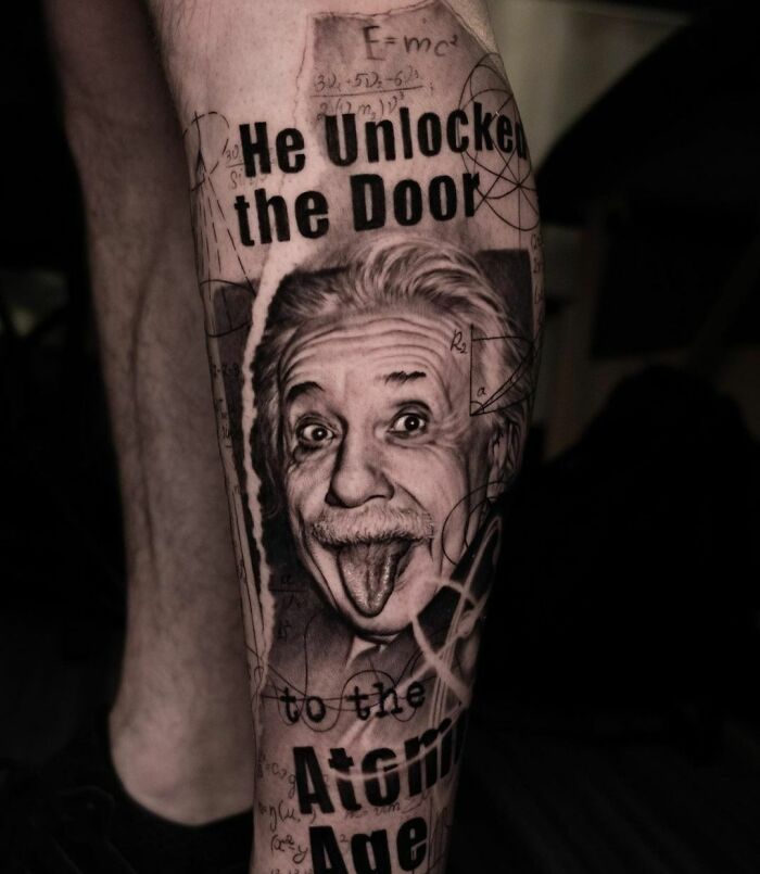 Black realistic Einstein showing tongue tattoo on leg