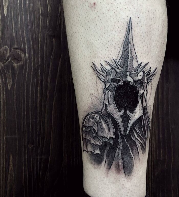 Arm tattoo of a detailed black and gray Sauron helmet from Lord of the Rings.
