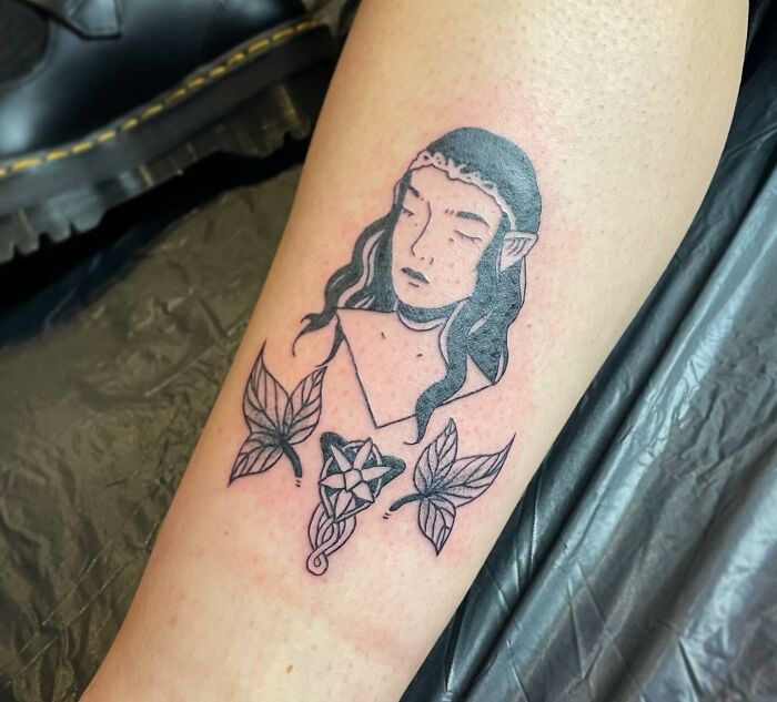 "Lord of the Rings tattoo featuring an elf with long hair and leaves, inspired by fantasy themes."
