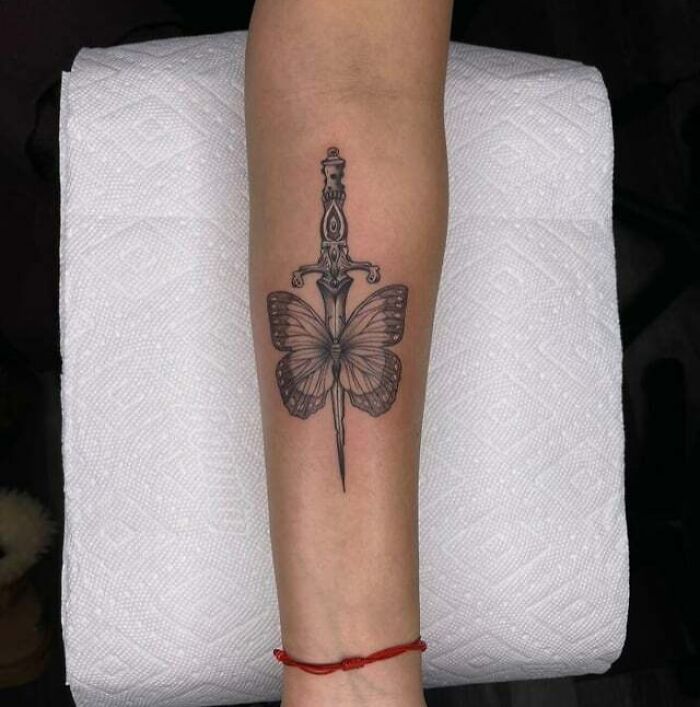 butterfly with dagger arm tattoo