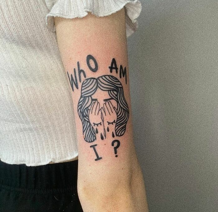 "Who Am I?" and crying face tattoo 