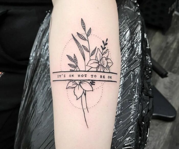 "It's Okay Not To Be Okay" phrase and flowers tattoo