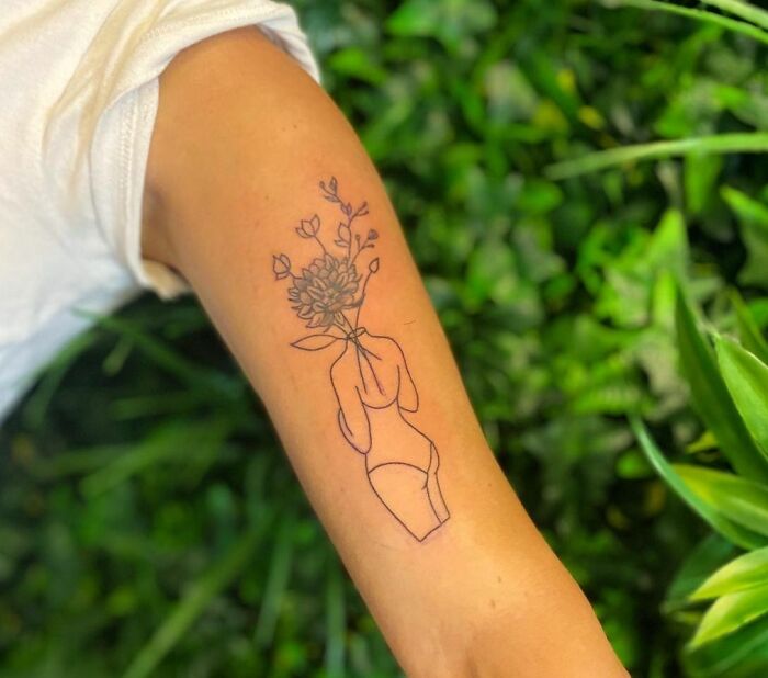 Woman's body with flowers instead of a head tattoo