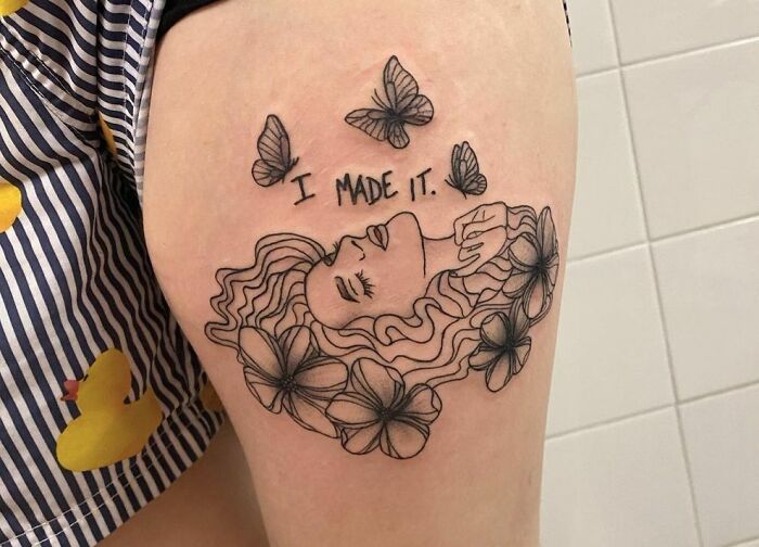 Female with butterflies and flowers "I made it " inscription tattoo 