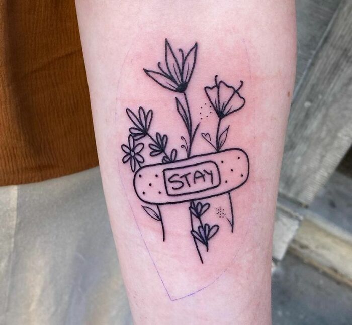 Patch with "stay" word on it attched to flowers tattoo