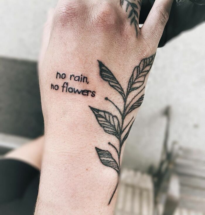 "No rain no flower" inscription and leafs tattoo